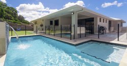 a backyard with a crystal clear pool in time for summer. Follow our maintenance guide to keep your pool crystal clear all summer.